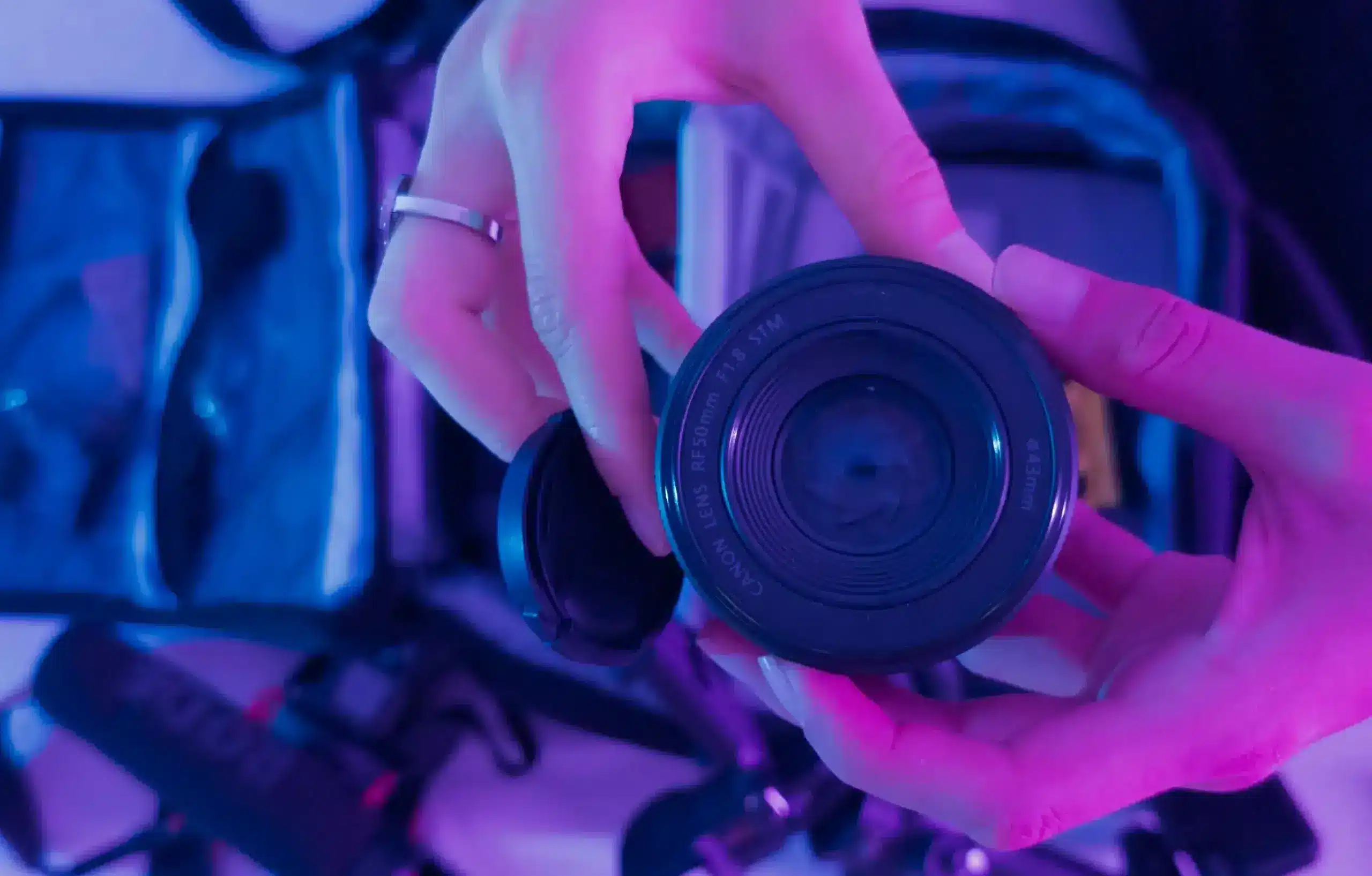 Close-up of Canon lens in Andrea Quintero’s hands, symbolizing storytelling through photography and film.